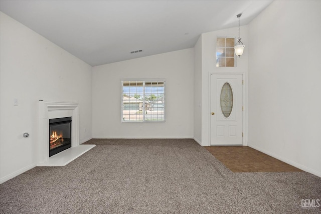 foyer entrance with baseboards, visible vents, a glass covered fireplace, and carpet