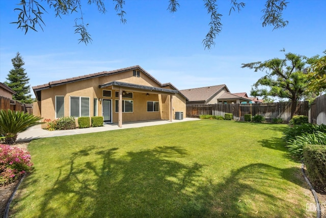 back of property featuring a fenced backyard, stucco siding, a ceiling fan, a patio area, and a lawn