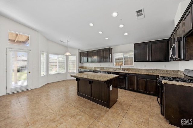 kitchen with light tile patterned flooring, a sink, stainless steel appliances, lofted ceiling, and visible vents