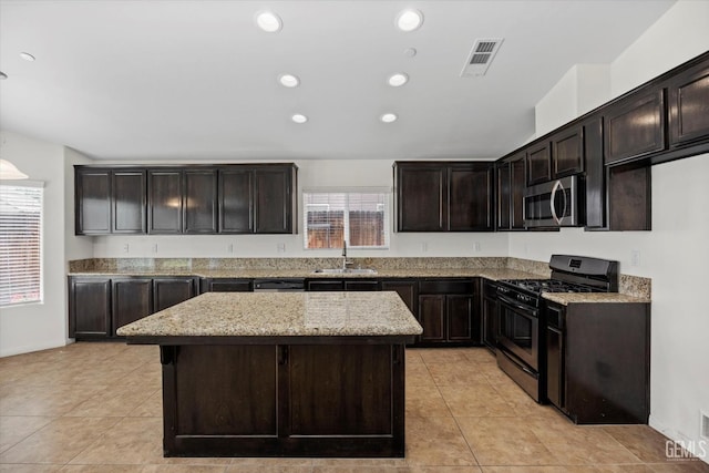 kitchen featuring visible vents, a sink, light tile patterned floors, stainless steel microwave, and range with gas stovetop
