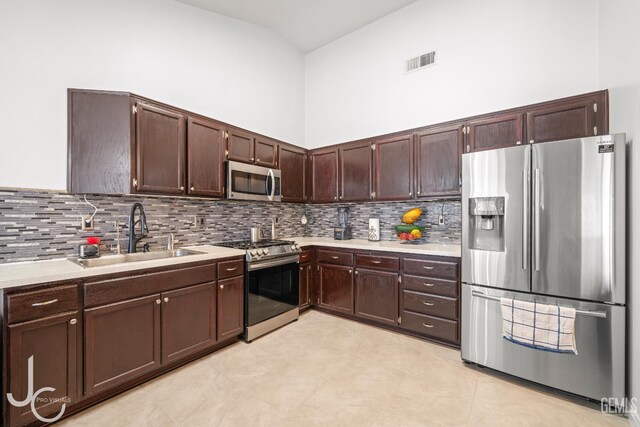 408 Isla Bonita St, Bakersfield, CA 93307 - kitchen with stainless steel appliances, light countertops, tasteful backsplash, and dark brown cabinetry
