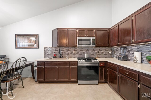 408 Isla Bonita St, Bakersfield, CA 93307 - kitchen with stainless steel appliances, vaulted ceiling, tasteful backsplash, light countertops, and dark brown cabinetry