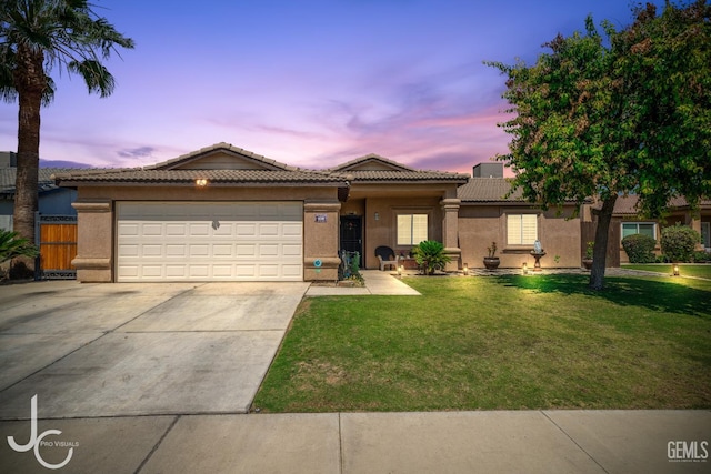 408 Isla Bonita St, Bakersfield, CA 93307 - view of front of home with driveway, stucco siding, an attached garage, and a lawn