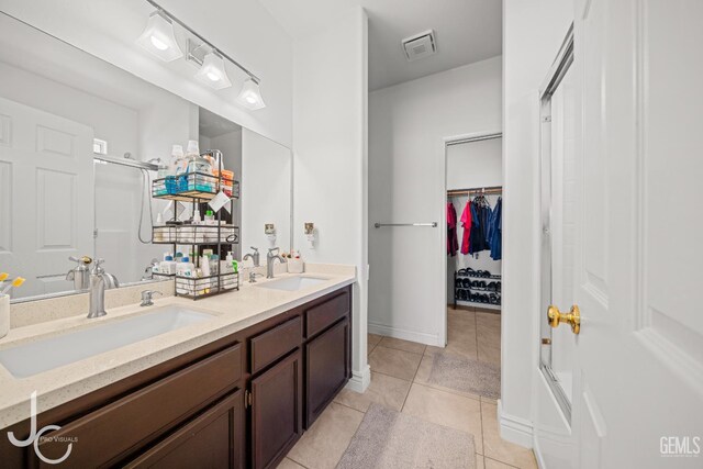 408 Isla Bonita St, Bakersfield, CA 93307 - full bathroom with tile patterned flooring, double vanity, a shower, and a spacious closet