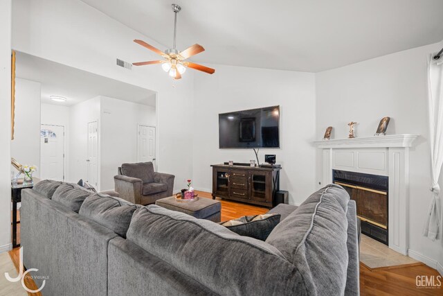 408 Isla Bonita St, Bakersfield, CA 93307 - living area featuring light wood-type flooring, a ceiling fan, vaulted ceiling, and a tile fireplace