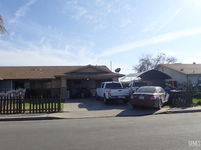 view of front facade featuring an attached garage, a fenced front yard, and concrete driveway