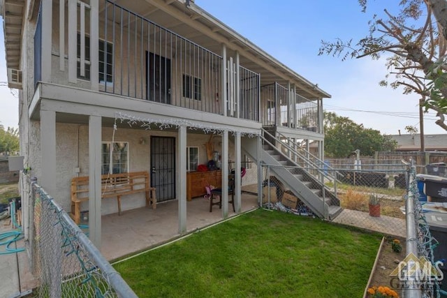 back of house with a patio and a lawn