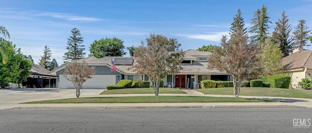 11520 Pinehaven Ave, Bakersfield, CA 93312 - view of front of home with driveway, solar panels, a front lawn, and an attached garage
