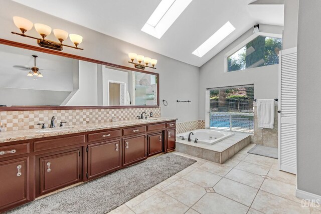 11520 Pinehaven Ave, Bakersfield, CA 93312 - bathroom with double vanity, a skylight, a bath, tile patterned floors, and decorative backsplash