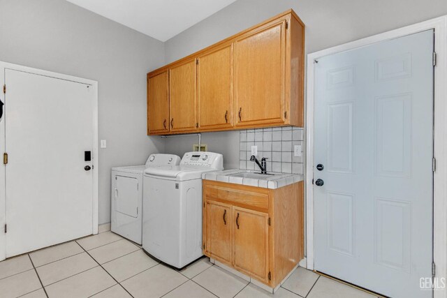 11520 Pinehaven Ave, Bakersfield, CA 93312 - washroom featuring cabinet space, washer and dryer, and light tile patterned floors