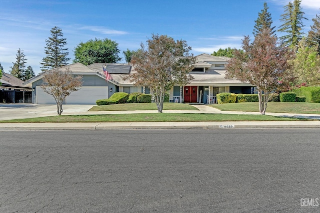 11520 Pinehaven Ave, Bakersfield, CA 93312 - view of property hidden behind natural elements with solar panels, driveway, a front yard, a garage, and a tile roof