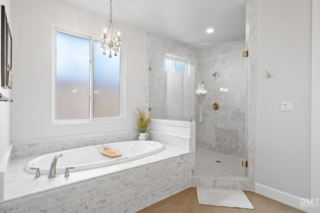 full bath with a bath, tile patterned floors, an inviting chandelier, and a stall shower