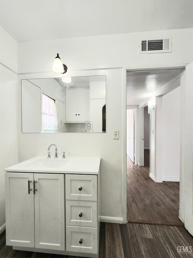 209 Bedford Way, Bakersfield, CA 93308 - bathroom featuring visible vents, vanity, baseboards, and wood finished floors
