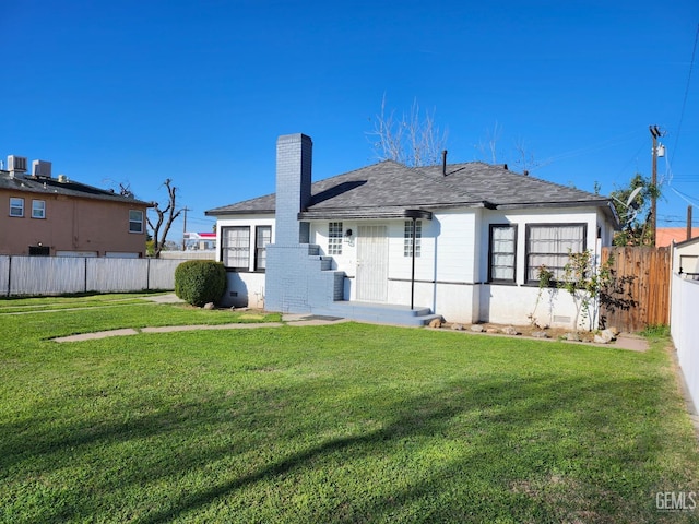 209 Bedford Way, Bakersfield, CA 93308 - rear view of property featuring a yard, a shingled roof, a chimney, and fence