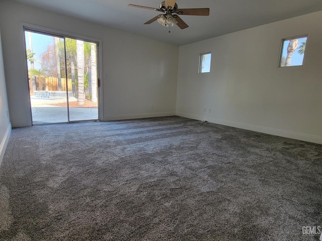 spare room with ceiling fan, a healthy amount of sunlight, and dark colored carpet