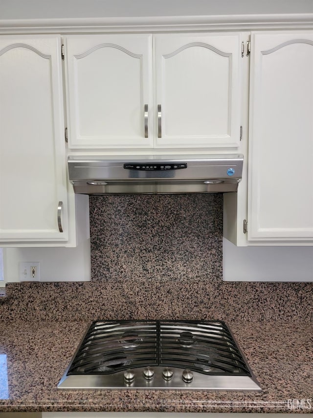 interior details featuring white cabinetry, gas stovetop, backsplash, and exhaust hood