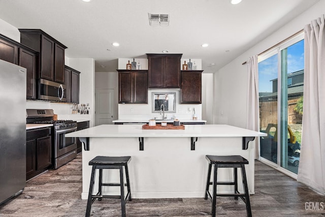 5906 Commonwealth Ave, Bakersfield, CA 93313 - kitchen with stainless steel appliances, light countertops, dark wood-style floors, recessed lighting, and a kitchen island