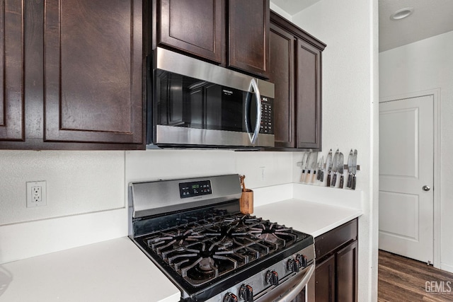 5906 Commonwealth Ave, Bakersfield, CA 93313 - kitchen featuring stainless steel appliances, dark brown cabinets, light countertops, and dark wood-style flooring