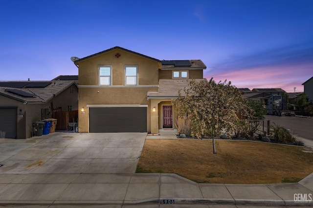 5906 Commonwealth Ave, Bakersfield, CA 93313 - view of front of house featuring roof mounted solar panels, an attached garage, driveway, and stucco siding