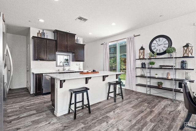 5906 Commonwealth Ave, Bakersfield, CA 93313 - kitchen featuring dark wood-type flooring, light countertops, dishwasher, a kitchen breakfast bar, and a center island