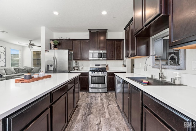 5906 Commonwealth Ave, Bakersfield, CA 93313 - kitchen with stainless steel appliances, wood finished floors, light countertops, open floor plan, and ceiling fan