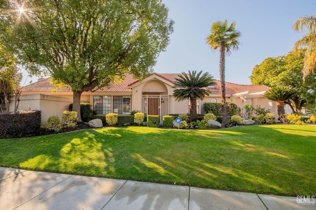 mediterranean / spanish home featuring a front lawn