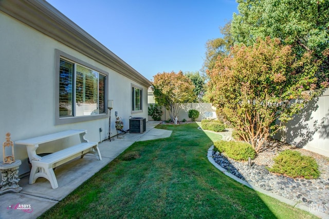 view of yard with central AC unit and a patio area