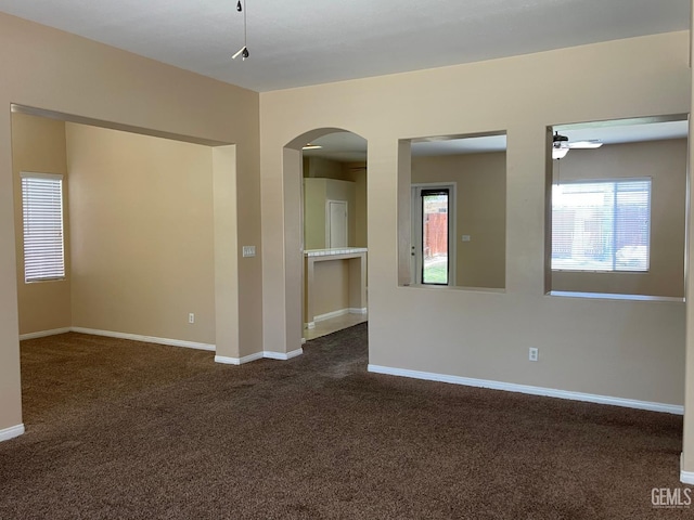 11016 Snowcreek Falls Ave, Bakersfield, CA 93312 - spare room featuring dark carpet, arched walkways, and ceiling fan