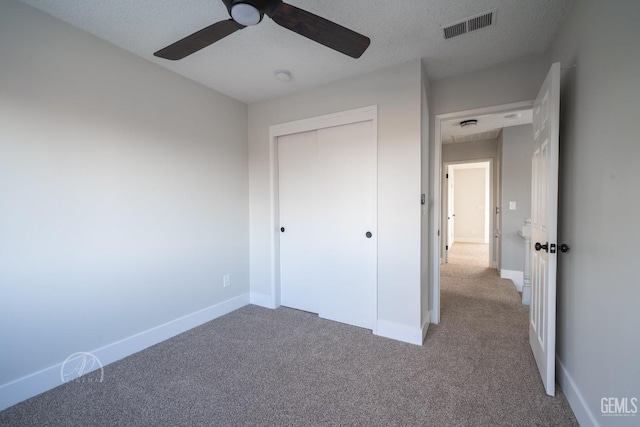 unfurnished bedroom featuring ceiling fan, a closet, carpet, and a textured ceiling