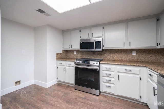 kitchen with white cabinetry, backsplash, wood-type flooring, and stainless steel appliances