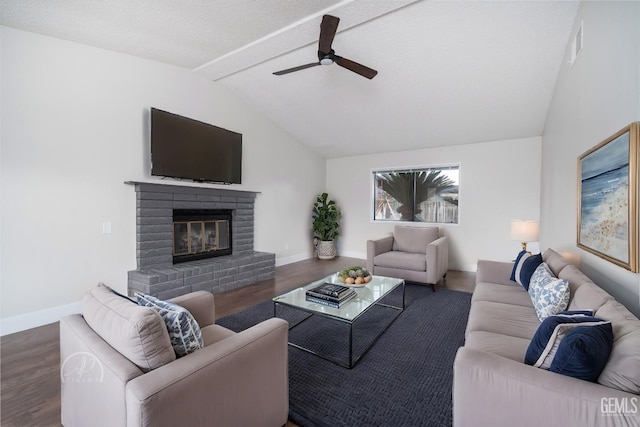 living room with ceiling fan, lofted ceiling, dark hardwood / wood-style flooring, and a brick fireplace