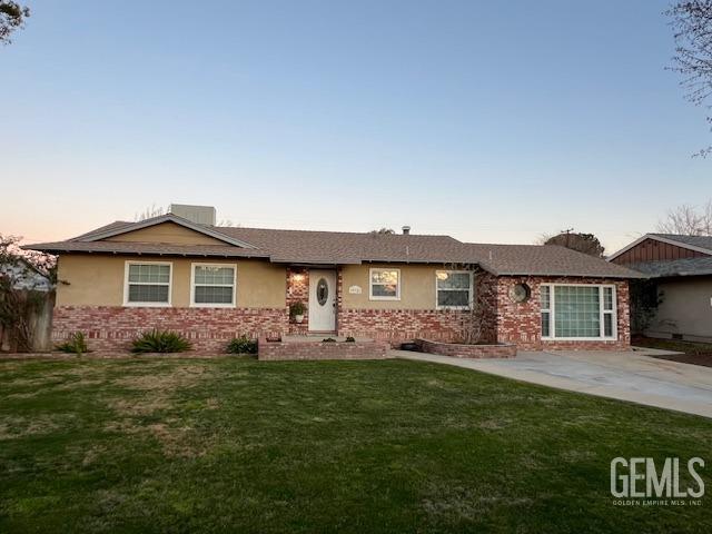 single story home featuring a lawn