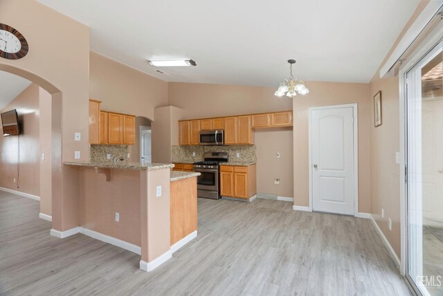 3406 Kimmie Rachelle Ct, Bakersfield, CA 93313 - kitchen with stainless steel appliances, vaulted ceiling, arched walkways, tasteful backsplash, and a peninsula