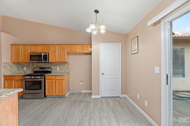 3406 Kimmie Rachelle Ct, Bakersfield, CA 93313 - kitchen featuring appliances with stainless steel finishes, light wood finished floors, vaulted ceiling, decorative backsplash, and a chandelier