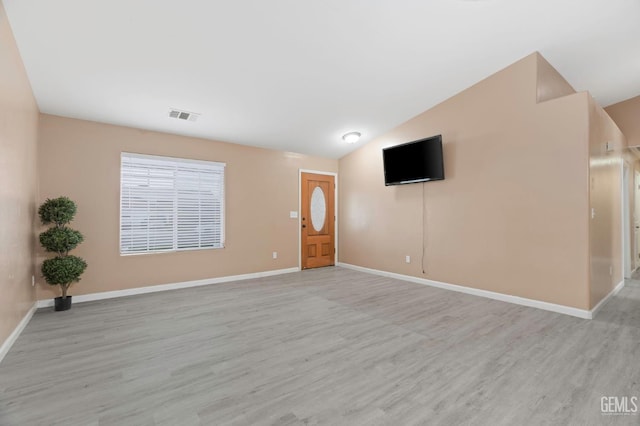 3406 Kimmie Rachelle Ct, Bakersfield, CA 93313 - unfurnished living room with lofted ceiling, light wood finished floors, and baseboards