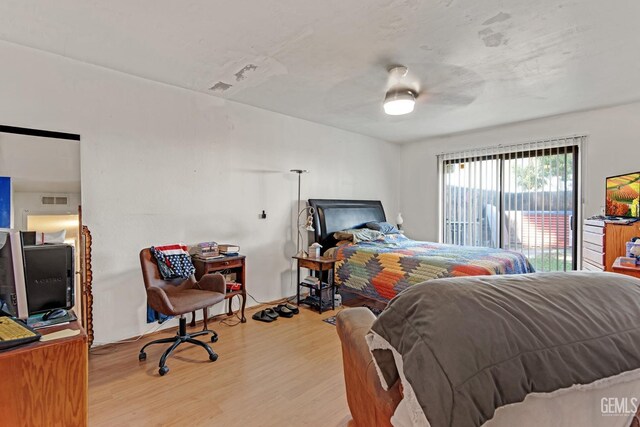 bedroom featuring wood finished floors, a ceiling fan, and access to exterior