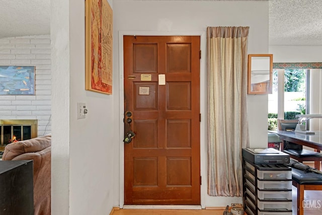 foyer entrance with a fireplace and a textured ceiling