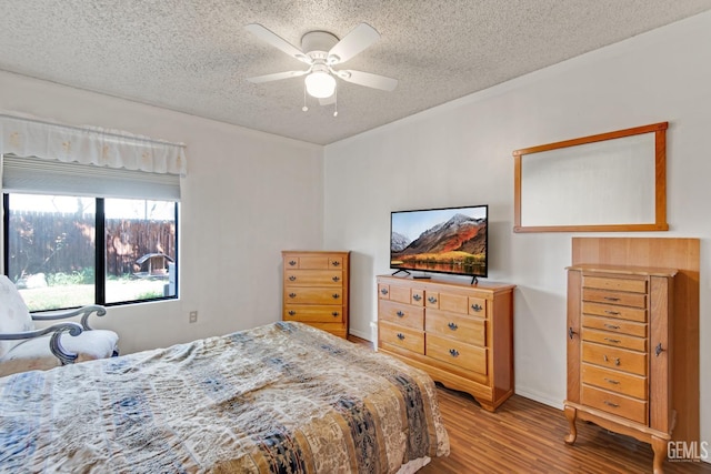 bedroom featuring ceiling fan, light wood-style flooring, and a textured ceiling