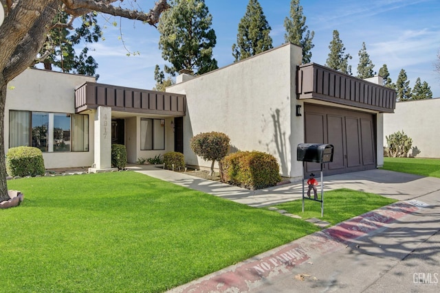 exterior space featuring a front yard, a balcony, and stucco siding