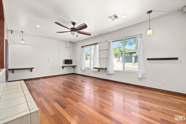 unfurnished living room with wood-type flooring and ceiling fan