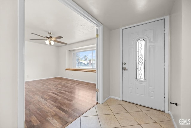 foyer entrance featuring light tile patterned floors and ceiling fan