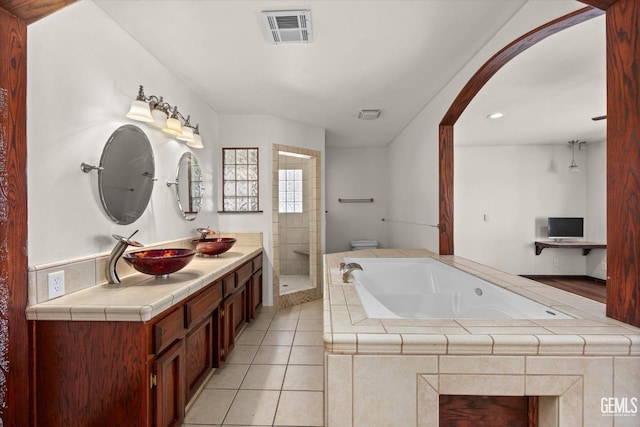 bathroom with tile patterned flooring, vanity, and independent shower and bath