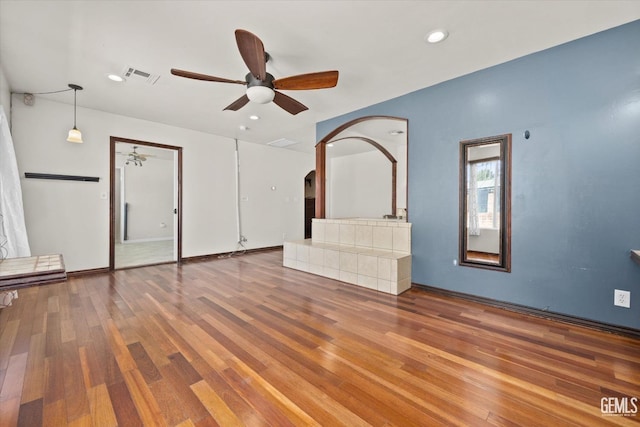 unfurnished living room featuring ceiling fan and hardwood / wood-style floors