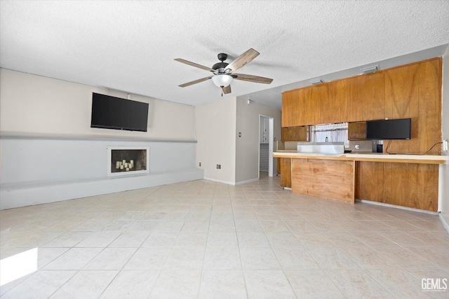 kitchen featuring kitchen peninsula, a textured ceiling, and ceiling fan