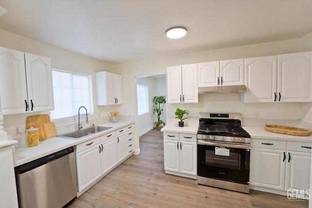 kitchen featuring white cabinetry, sink, stainless steel appliances, and light wood-type flooring