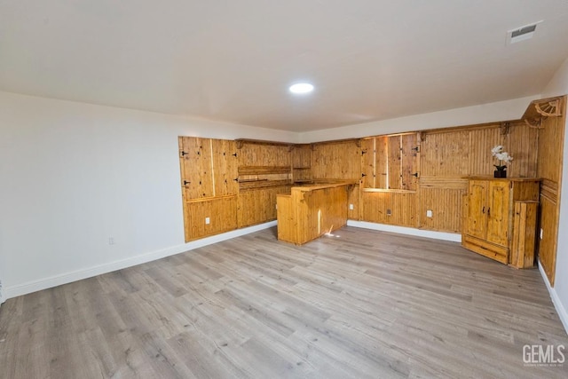 interior space with kitchen peninsula and light hardwood / wood-style floors