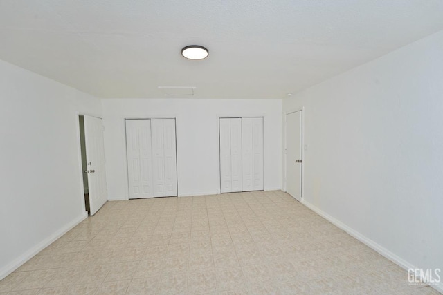 unfurnished bedroom with multiple closets