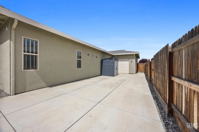 9003 Del Palma Dr, Bakersfield, CA 93314 - back of house with stucco siding, a patio area, and an attached garage