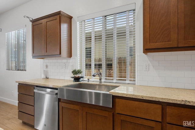 9003 Del Palma Dr, Bakersfield, CA 93314 - kitchen with stainless steel dishwasher, tasteful backsplash, light stone countertops, and light wood finished floors