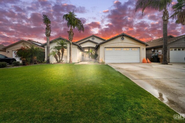 view of front of property featuring a lawn and a garage